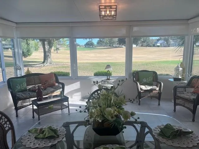a living room with furniture and floor to ceiling windows