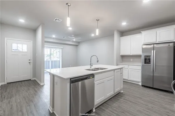 a kitchen with a sink window and refrigerator