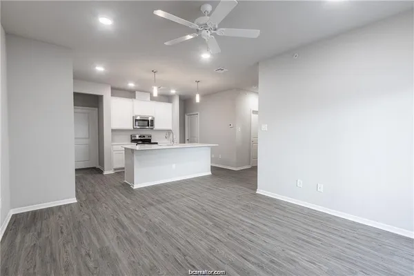 a view of kitchen with granite countertop cabinets and refrigerator