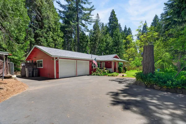 a front view of a house with a yard and trees