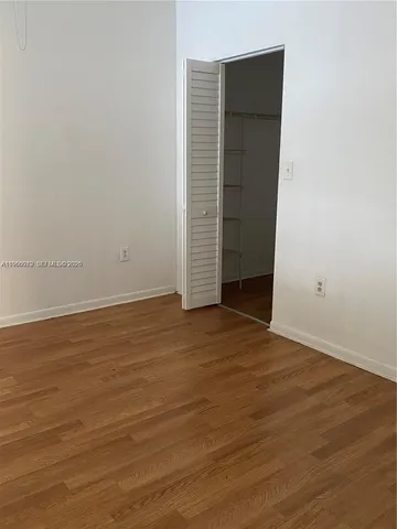 an empty room with wooden floor and closet