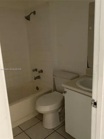 a white toilet sitting next to a bath tub