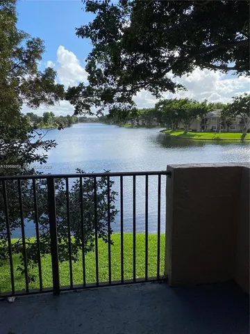 a balcony with wooden floor and lake view