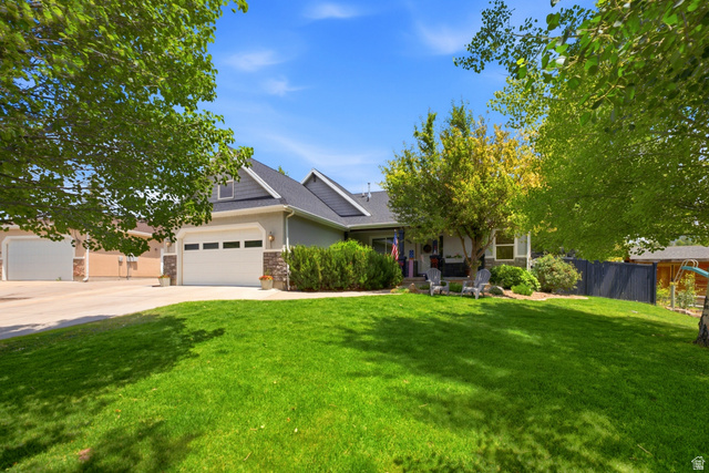 5196 Rodeo Circle Oakley, UT 84055 - Photo 1 of 57 Two-story residence featuring a gray exterior with stone accents, a dark shingle roof, and a prominent attached two-car garage