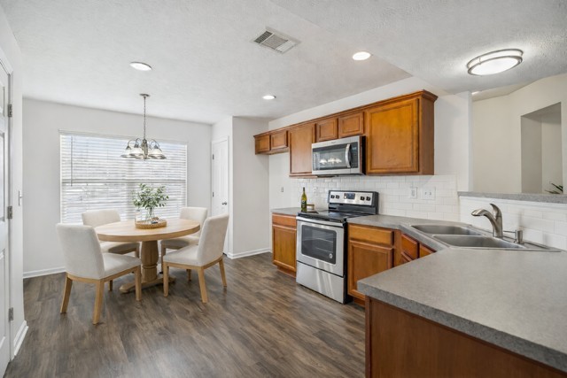 1791 Red Jacket Drive Antioch, TN 37013 - Photo 14 of 48 a kitchen with stainless steel appliances granite countertop a kitchen island hardwood floor sink stove dining table and chairs