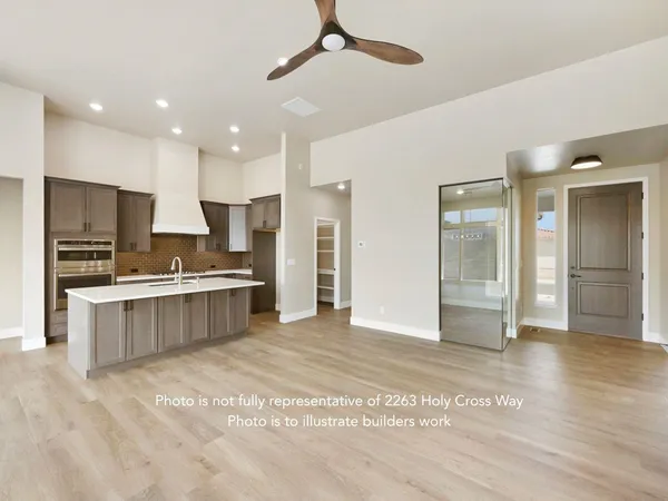 a large kitchen with stainless steel appliances kitchen island granite countertop a refrigerator and a sink