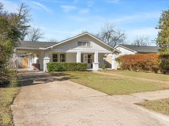 a front view of a house with a yard and potted plants