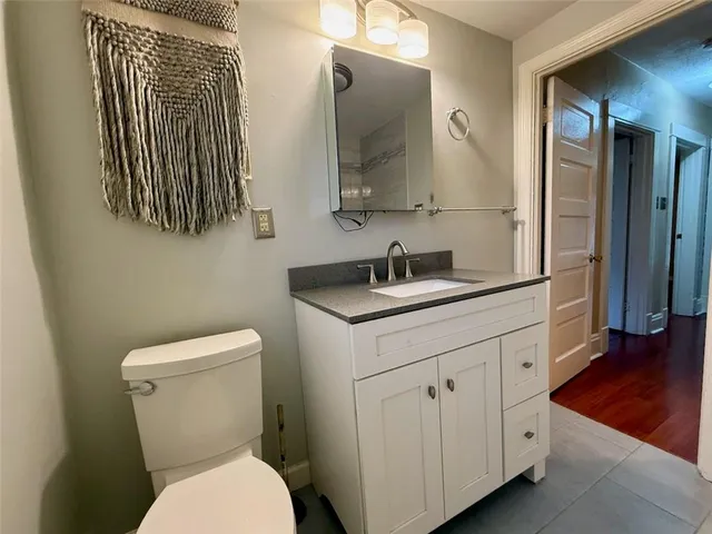 a bathroom with a toilet sink and mirror