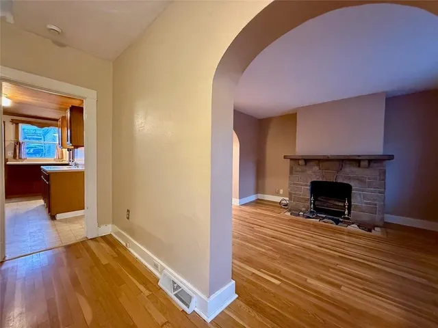 a view of a livingroom with wooden floor and a fireplace