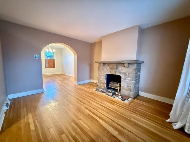 a view of a livingroom with wooden floor and a fireplace