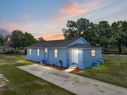a front view of a house with a yard and trees