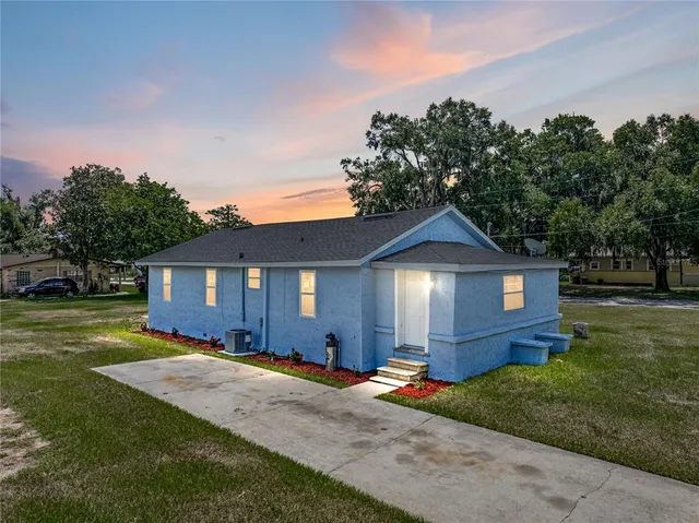 a front view of a house with a yard and trees
