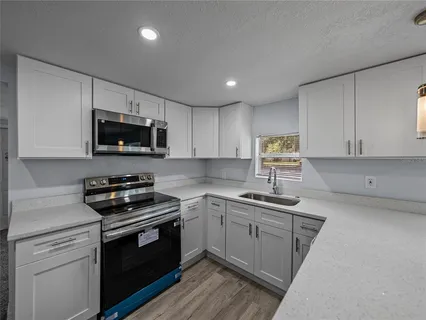 a kitchen with sink a microwave and cabinets