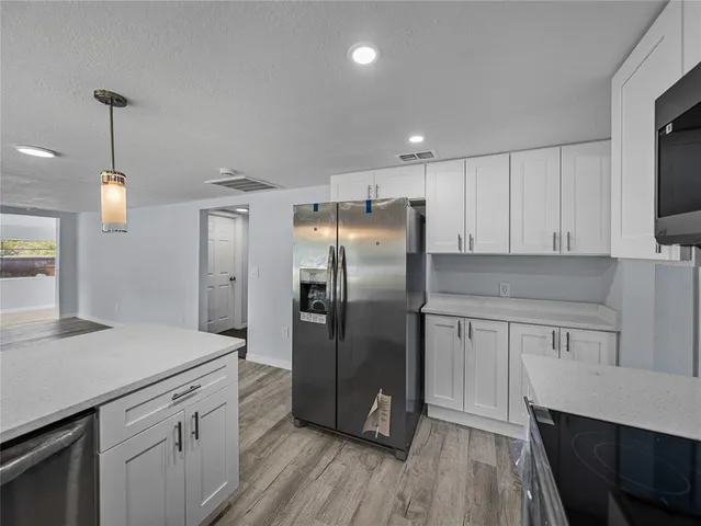 a kitchen with stainless steel appliances a refrigerator sink and microwave