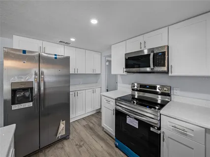 a kitchen with a refrigerator stove and microwave