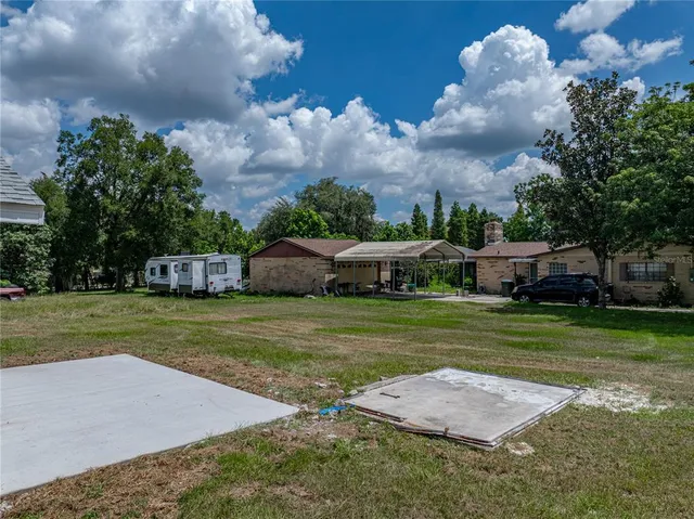 a front view of a house with a yard and trees