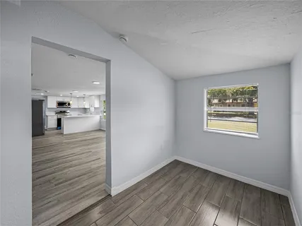 a view of a hallway with wooden floor and a living room