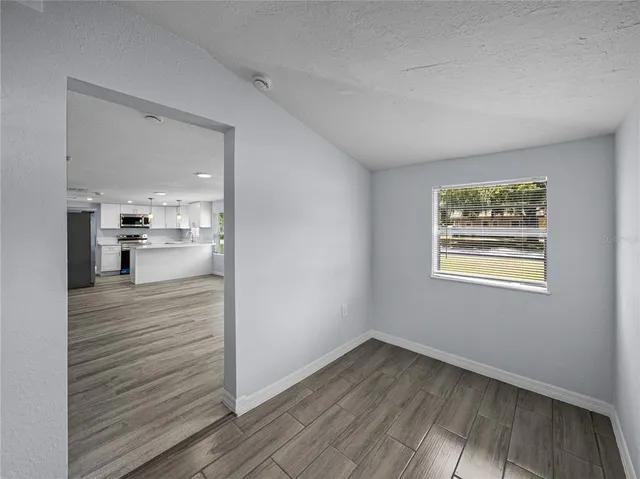 a view of a hallway with wooden floor and a living room