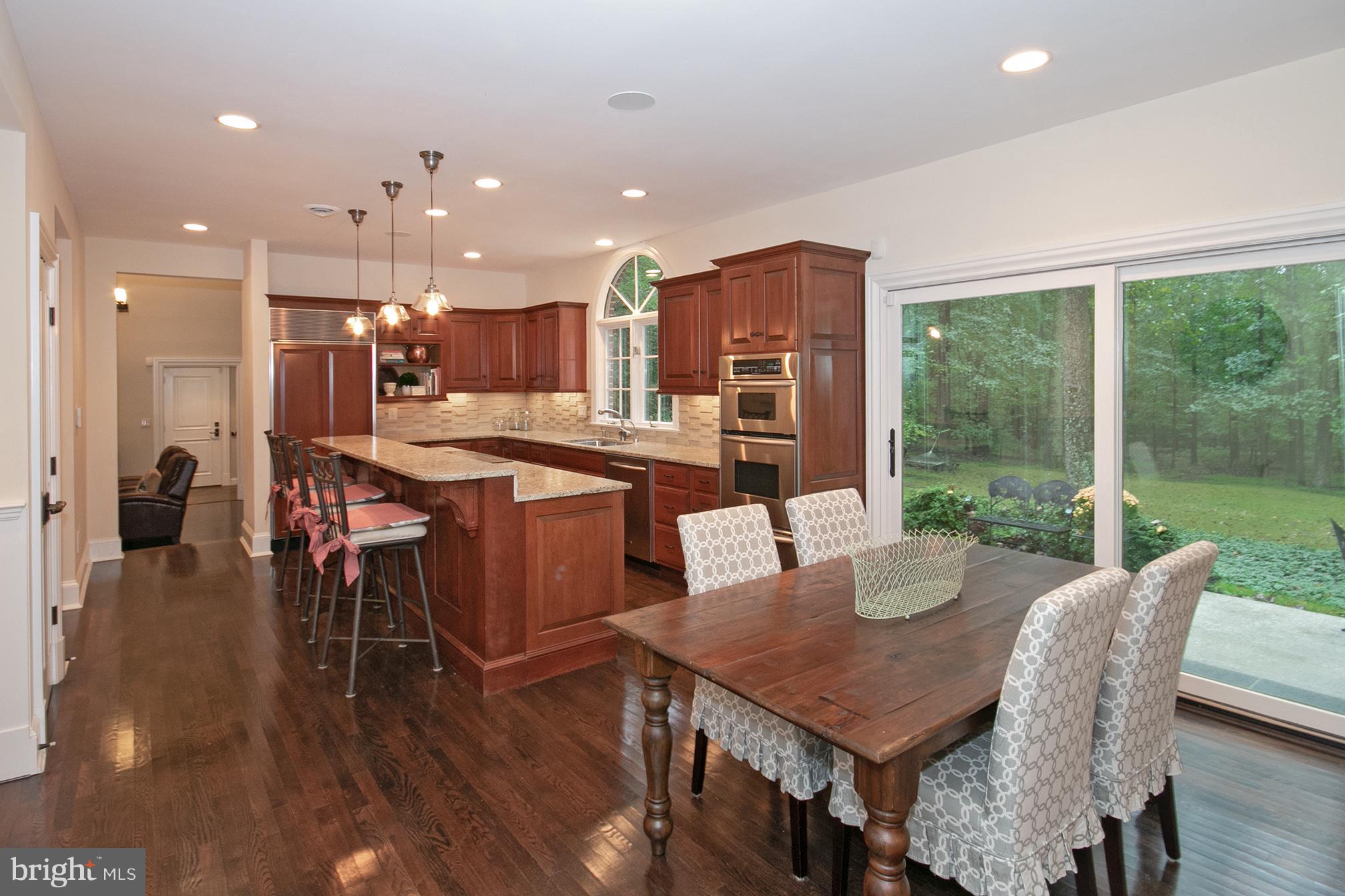 684 Springvale Road Great Falls, VA 22066 - Photo 5 of 27 a dining room with furniture a wooden floor and a floor to ceiling window