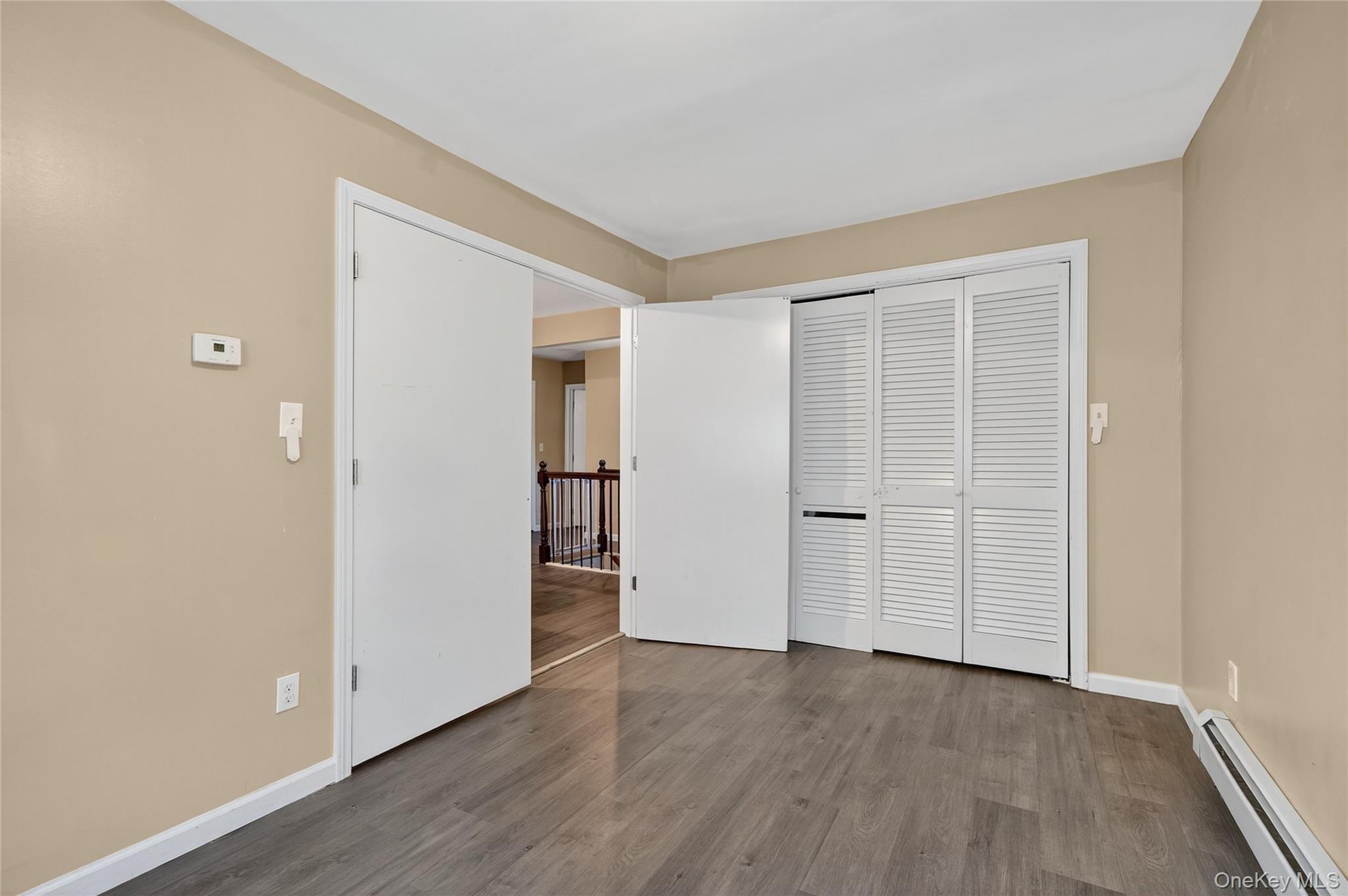 469 Hillside Road Monroe, NY 10950 - Photo 17 of 44 Unfurnished bedroom with a baseboard radiator, dark wood-style floors, and a closet
