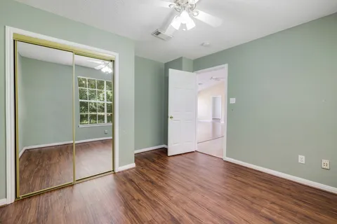 an empty room with wooden floor and windows