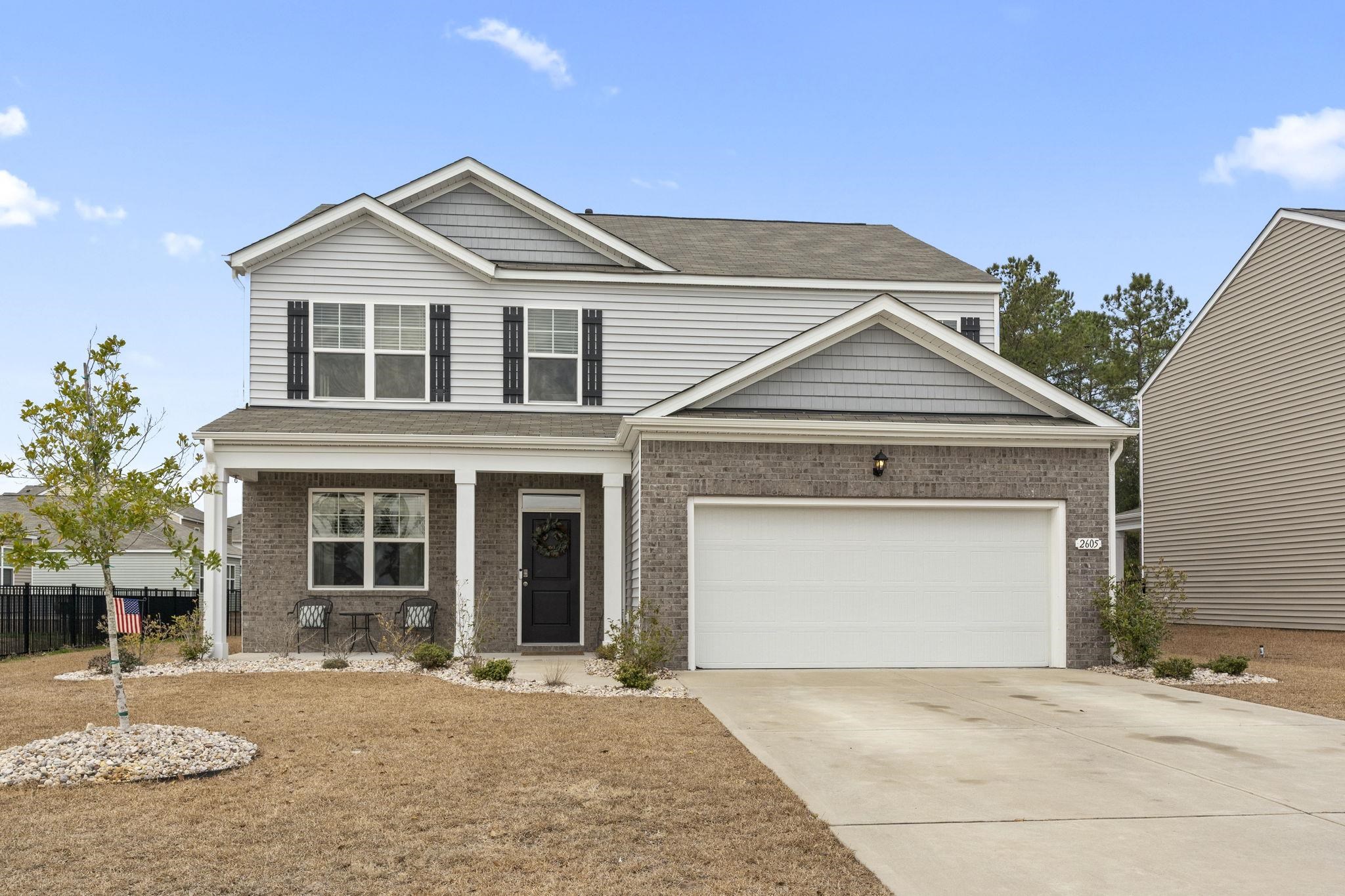 2605 Muhly Court Conway, SC 29526 - Photo 32 of 33 View of front of house with covered porch, concrete driveway, brick siding, and a shingled roof