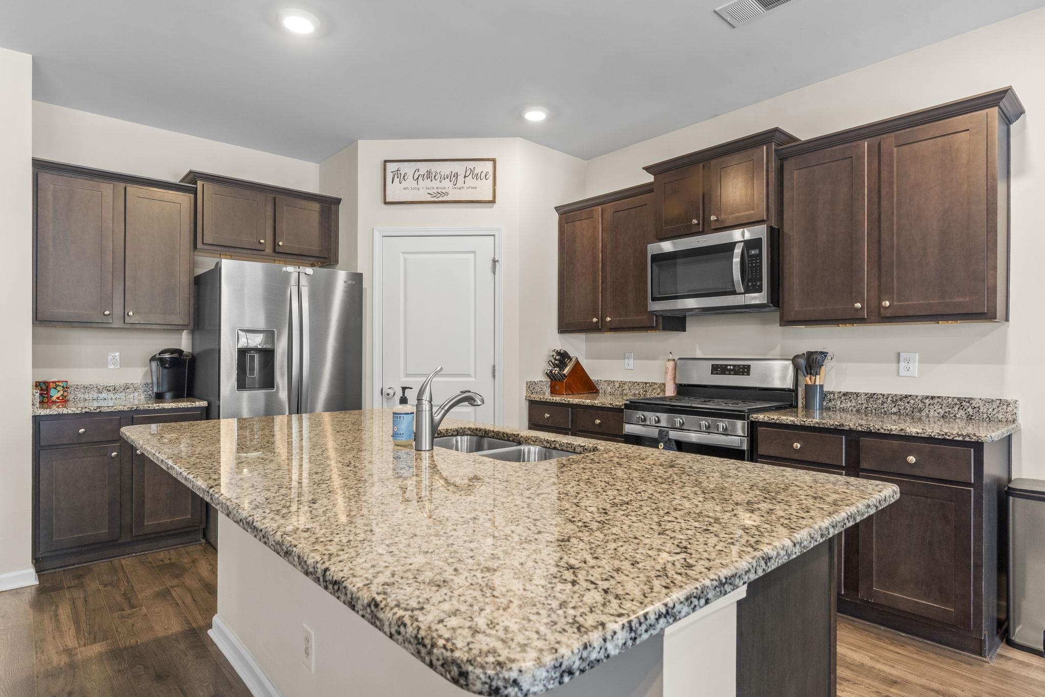 2605 Muhly Court Conway, SC 29526 - Photo 5 of 33 Kitchen with dark brown cabinetry, stainless steel appliances, light stone countertops, and recessed lighting