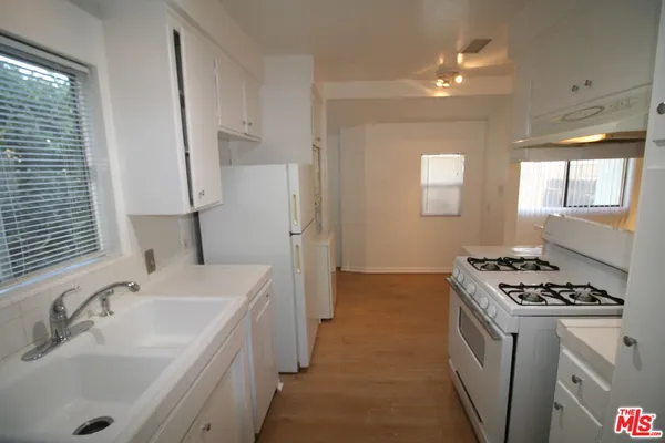 a kitchen with sink a stove and refrigerator