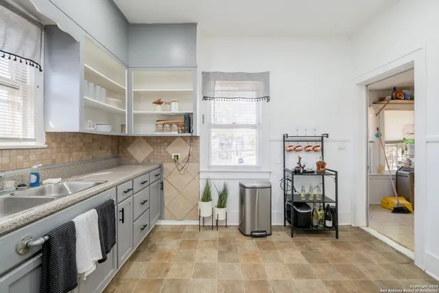 a kitchen that has a lot of cabinets in it and wooden floors
