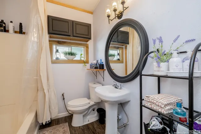 a bathroom with a toilet a sink and a mirror