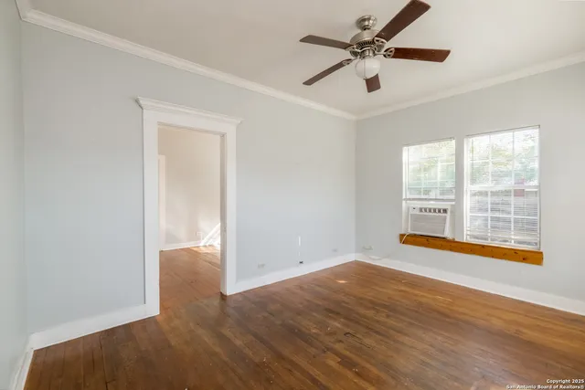 an empty room with fan and windows
