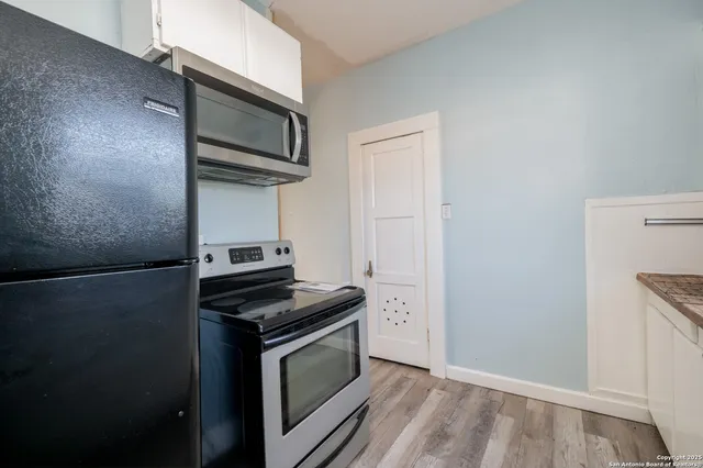 a kitchen with stainless steel appliances a stove microwave and refrigerator