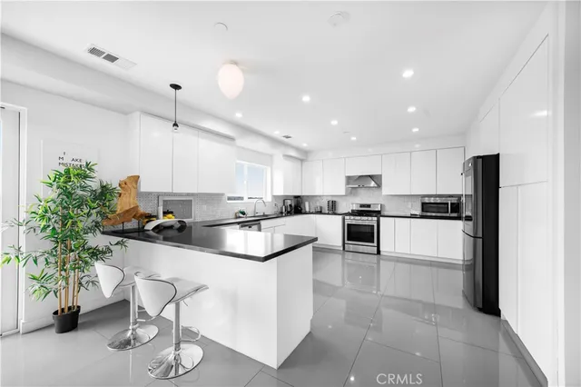 a kitchen with white cabinets and refrigerator