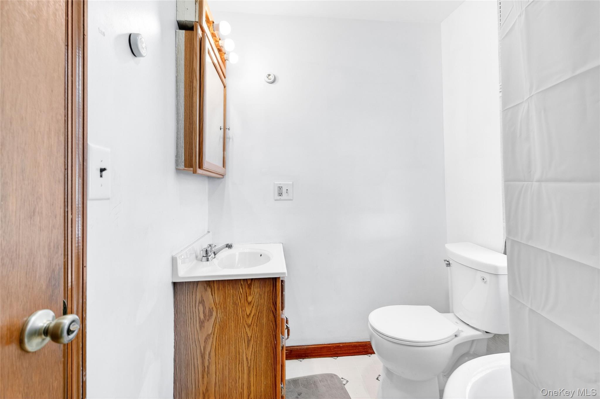 131 Front Street Port Jervis, NY 12771 - Photo 28 of 35 Half bath with vanity, toilet, and baseboards