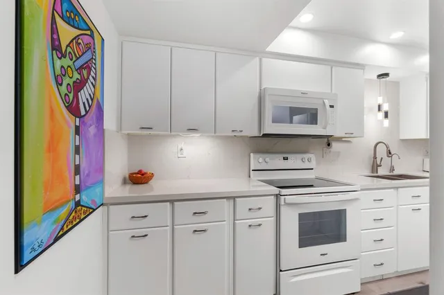 a kitchen with stainless steel appliances cabinets and a window