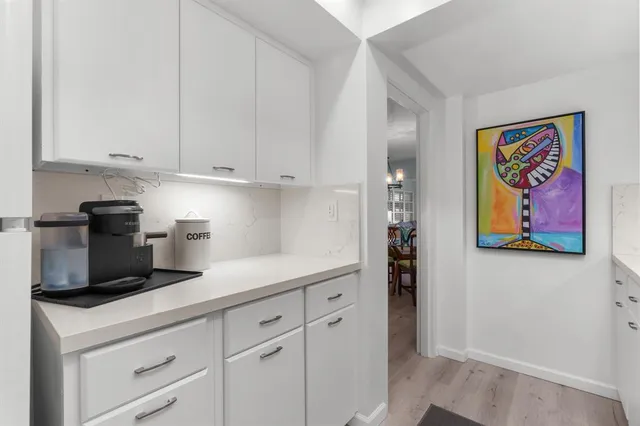 a kitchen with stainless steel appliances white cabinets and a refrigerator