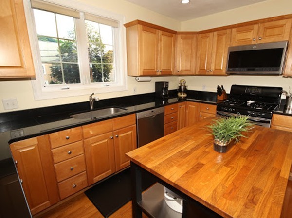 5 Melvin Street, Unit B Wakefield, MA 01880 - Photo 6 of 28 a kitchen with stainless steel appliances granite countertop a sink a stove and a microwave