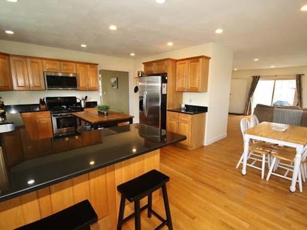 5 Melvin Street, Unit B Wakefield, MA 01880 - Photo 7 of 28 a kitchen with stainless steel appliances granite countertop sink stove refrigerator and wooden floor