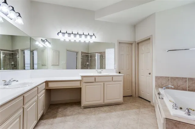 a spacious bathroom with a granite countertop sink mirror and bathtub
