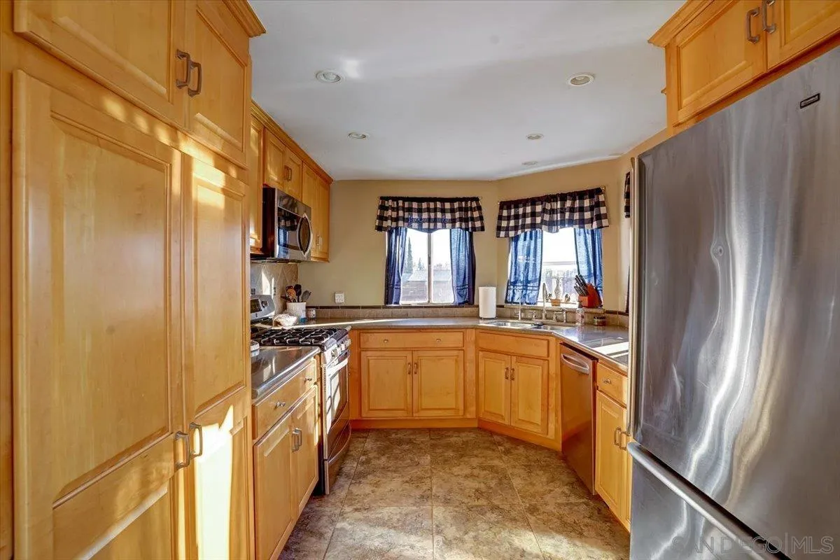 132 Mercedes Road Fallbrook, CA 92028 - Photo 12 of 63 a kitchen with stainless steel appliances granite countertop a refrigerator a sink dishwasher a stove and white countertops with wooden floor