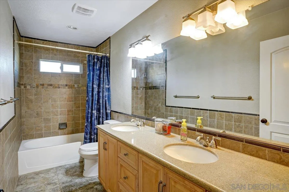 132 Mercedes Road Fallbrook, CA 92028 - Photo 13 of 63 a bathroom with a granite countertop sink a toilet and bathtub