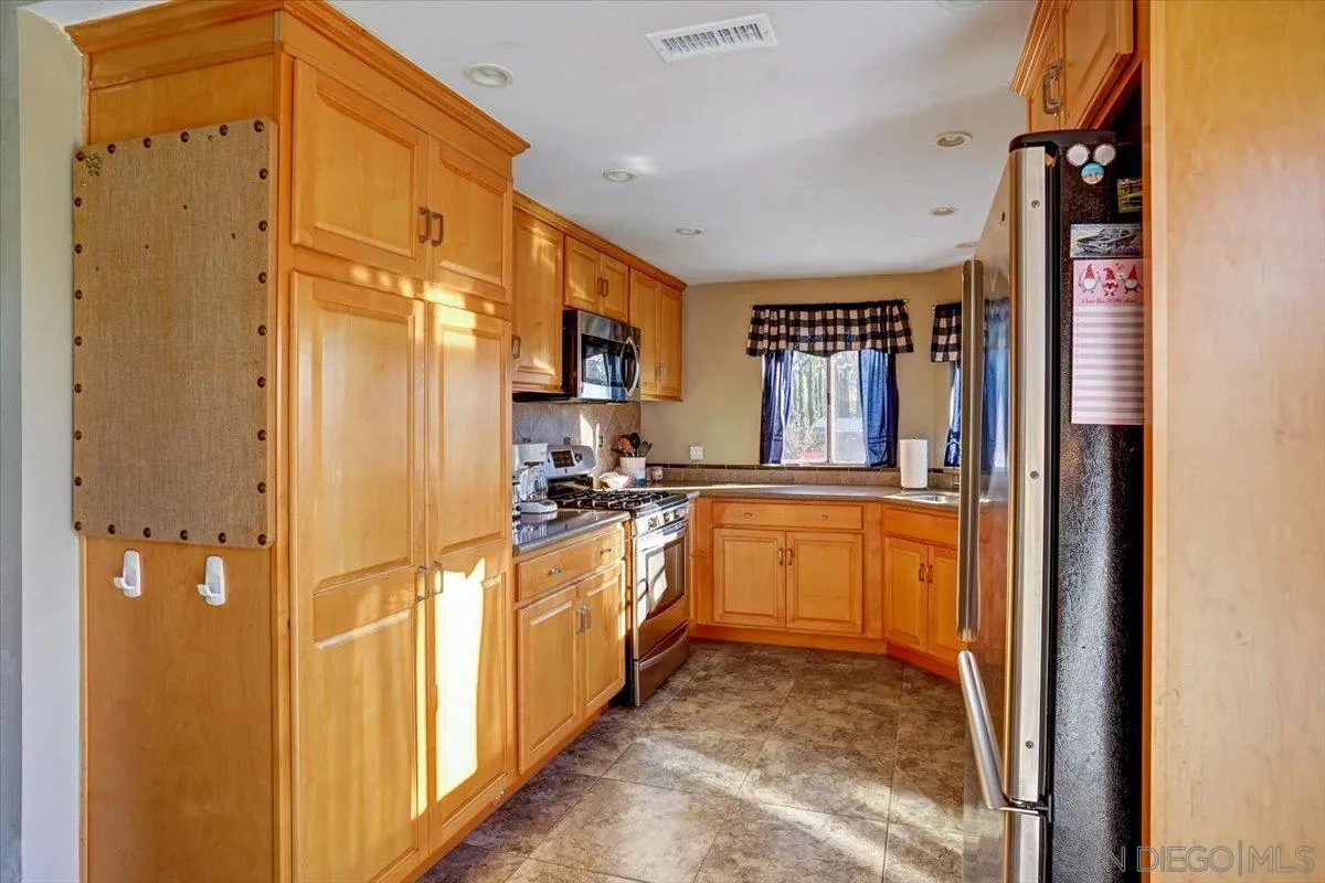 132 Mercedes Road Fallbrook, CA 92028 - Photo 10 of 63 a kitchen with stainless steel appliances granite countertop a refrigerator and a stove
