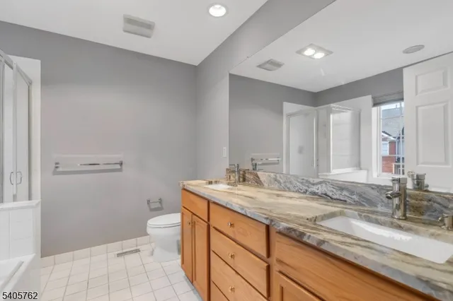 a bathroom with a granite countertop sink mirror vanity and toilet