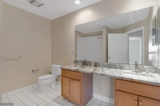 a bathroom with a granite countertop sink a toilet and a mirror