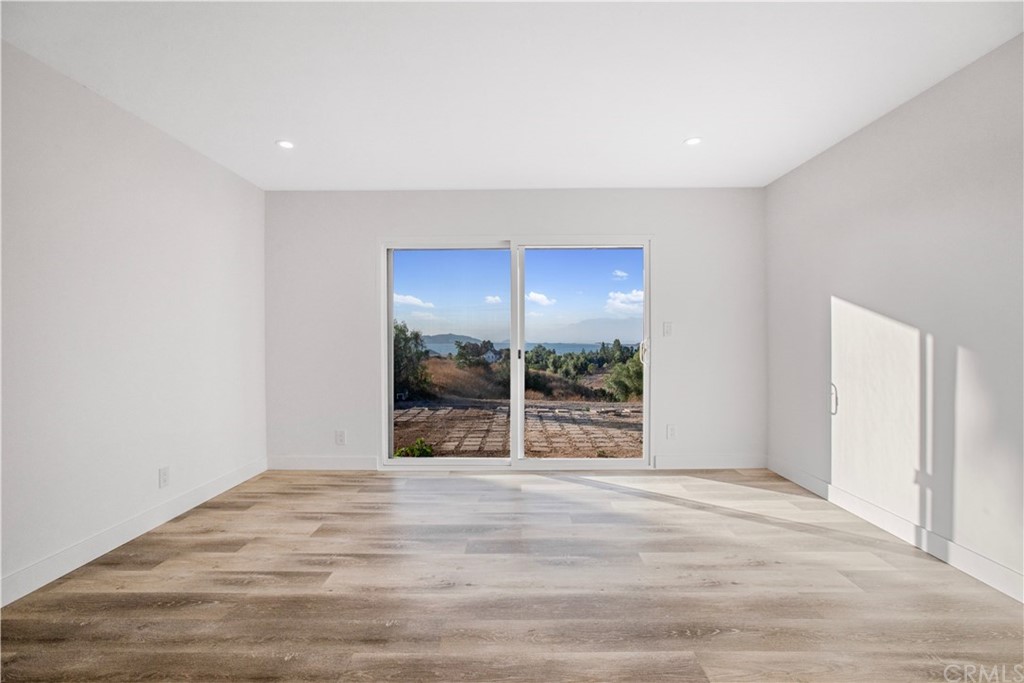 14265 Alva Place Perris, CA 92570 - Photo 17 of 59 a view of an empty room with wooden floor and a window