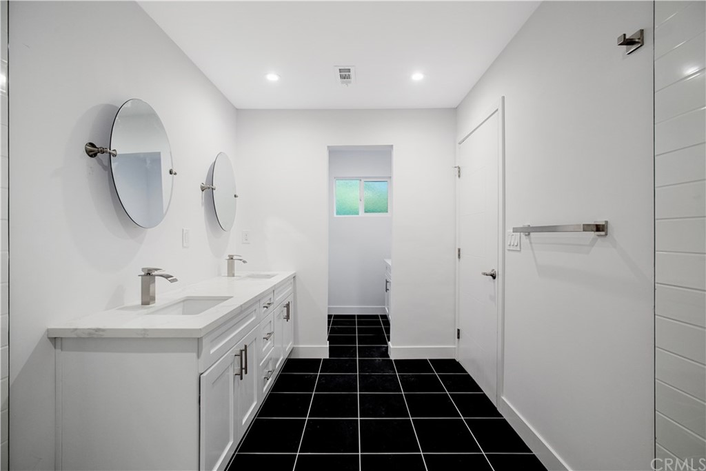 14265 Alva Place Perris, CA 92570 - Photo 31 of 59 a spacious bathroom with a double vanity sink a toilet and a mirror