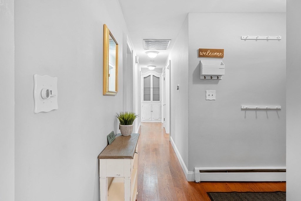 22 Bradley Road Danvers, MA 01923 - Photo 11 of 40 a hallway with painting on the wall and a potted plant