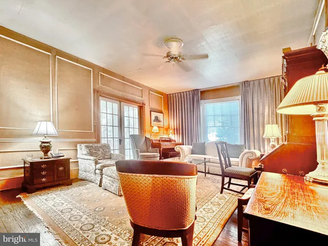 a living room with furniture a large window and a chandelier