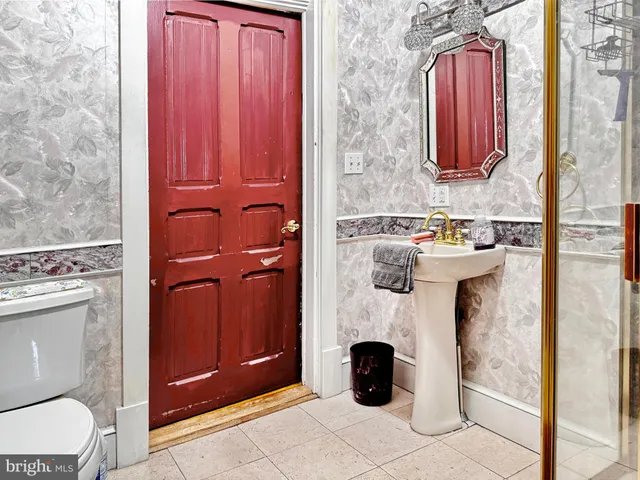 a bathroom with a toilet a sink and mirror