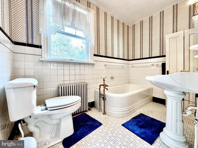 a bathroom with a sink toilet a mirror and bathtub